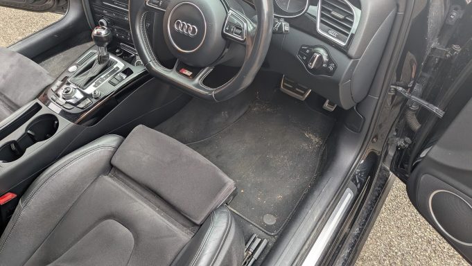 Audi S4 interior in Huntingdon, Cambridgeshire before detailing, driver’s footwell with visible dirt and debris.