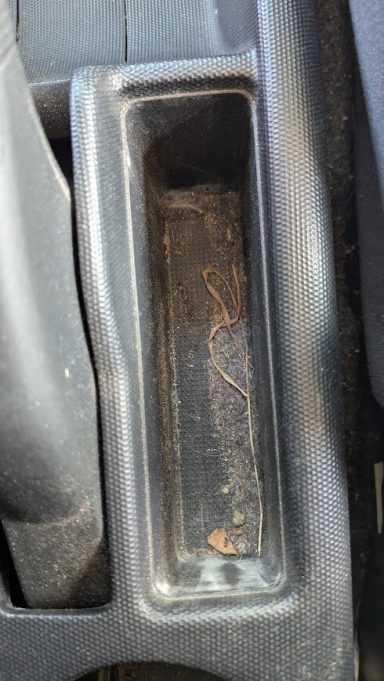 Dirty front centre console of a Honda Jazz in Market Deeping, Lincolnshire  before interior detailing, with debris visible.