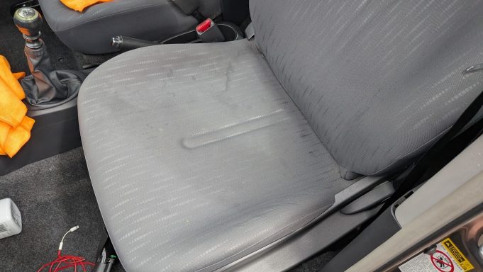 Stained passenger seat of a Toyota Yaris in Wisbech, Cambridgeshire before interior detailing, with visible marks on the fabric.