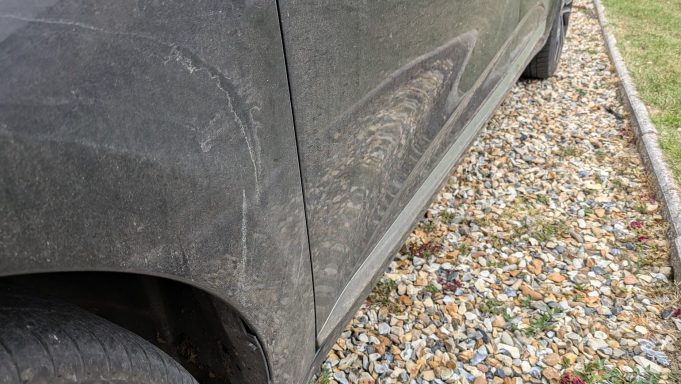 Renault Clio driver-side panel with dirt, tar, and road grime before detailing in Glinton, Peterborough