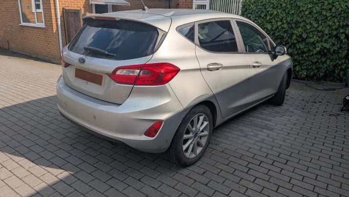 Rear view of a silver Ford Fiesta in Barnack, Peterborough before detailing, showing dirt on the bumper, tailgate and alloy wheels.