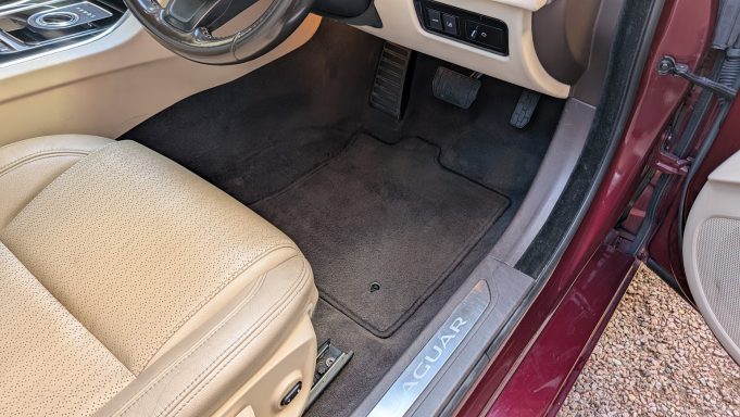 Driver’s footwell of a Jaguar XF in Cambridge after detailing, with freshly cleaned carpet mats and a tidy finish.