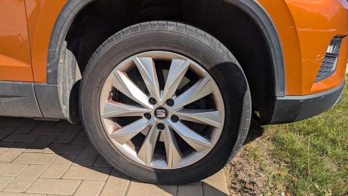 Front wheel of a Seat Ateca in Ely, Cambridgeshire before detailing, showing brake dust buildup and dirt across the alloy and arch.