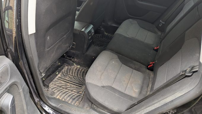 Volkswagen Passat rear seats in Bourne Lincolnshire before interior car detailing, showing dirt on the upholstery & debris on the floor mats